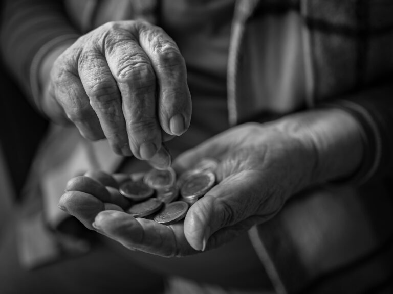 Manos de una persona mayor contando monedas – Devolución del IRPF a mutualistas