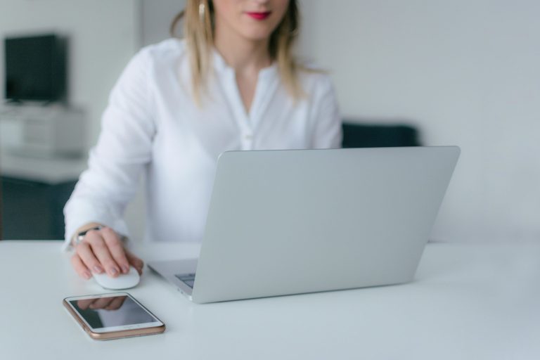 Mujer facturando con un portátil y un móvil – Guía VERI*FACTU