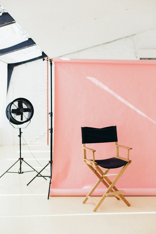 Plató de fotografía con fondo rosa y silla de director – Guía del plan de negocio