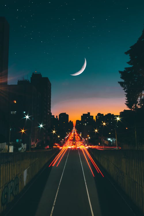 Carretera hacia la ciudad de noche con luna