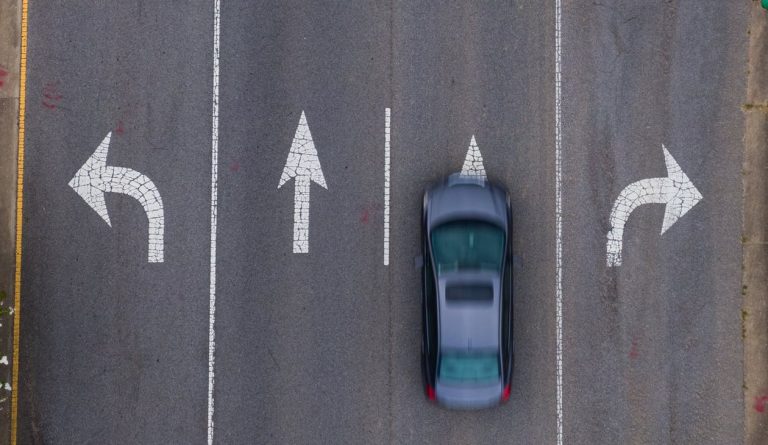 Coche visto desde arriba en un carril con flechas – Permiso de circulación y ficha técnica