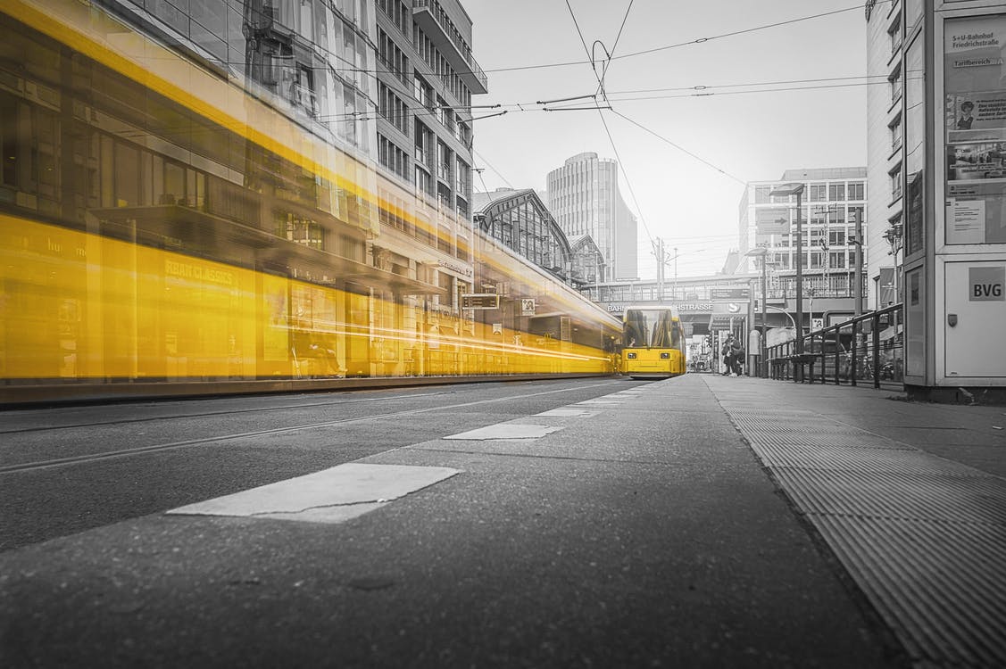 Tranvía amarillo difuminado por una calle urbana