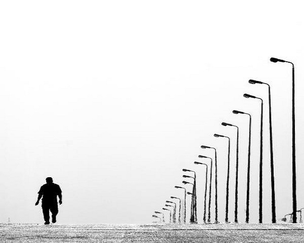 Hombre caminando junto a una hilera de farolas – Servicios fiscales: cambio de asesoría